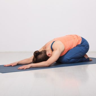 Beautiful sporty fit yogini woman practices yoga asana balasana