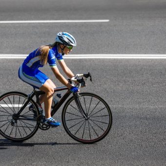 Female Cyclist Rides A Racing Bike On Road