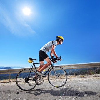 Cyclist riding a bicycle in Macedonia with a sun in the backgrou