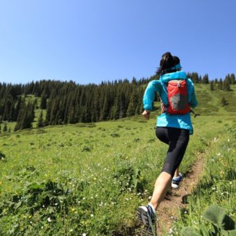 healthy young woman trail runner running on beautiful mountain peak
