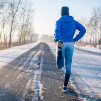 Runner Stretching In Winter Park. A Healthy Way Of Life.