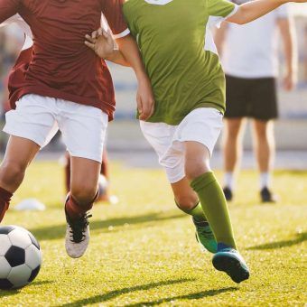 bigstock-Boys-Play-Football-Running-Fo-257570125