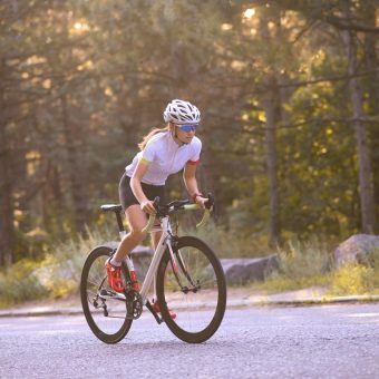 bigstock-Young-Woman-Cyclist-Riding-Roa-310498702